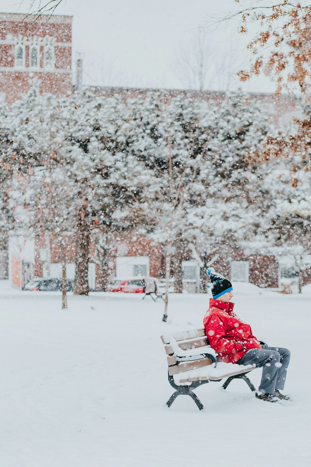 Personne portant une veste rouge assise sur un banc extérieur lors de la journée de remontoir