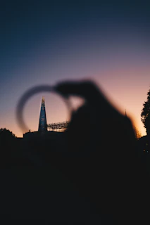 A panoramic view of London's iconic skyline at dusk, with the Shard and the Gherkin glowing against a deep blue sky.