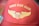 A red baseball cap features gold embroidered wings and the text 'Wings Over Miami.' The stitching includes a stylized emblem resembling a shield flanked by wings.