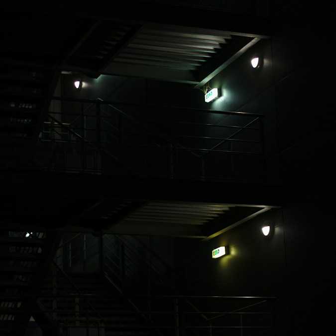 Escalier en bois éclairé dans une maison la nuit, en écho au récit de Benoît Poelvoorde (photo d’illustration)