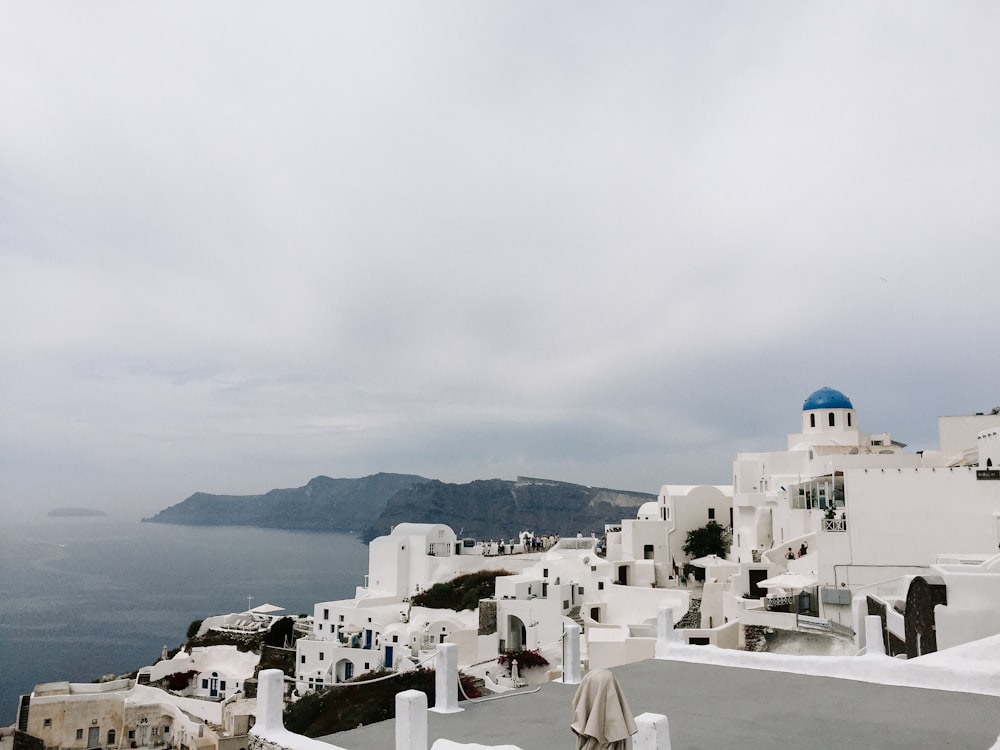 white concrete houses near body of water