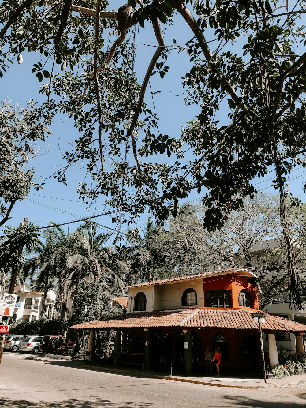 brown concrete house surrounded by green trees during daytime