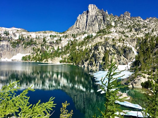reflection of cliff on body of water during daytime in The Enchantments United States