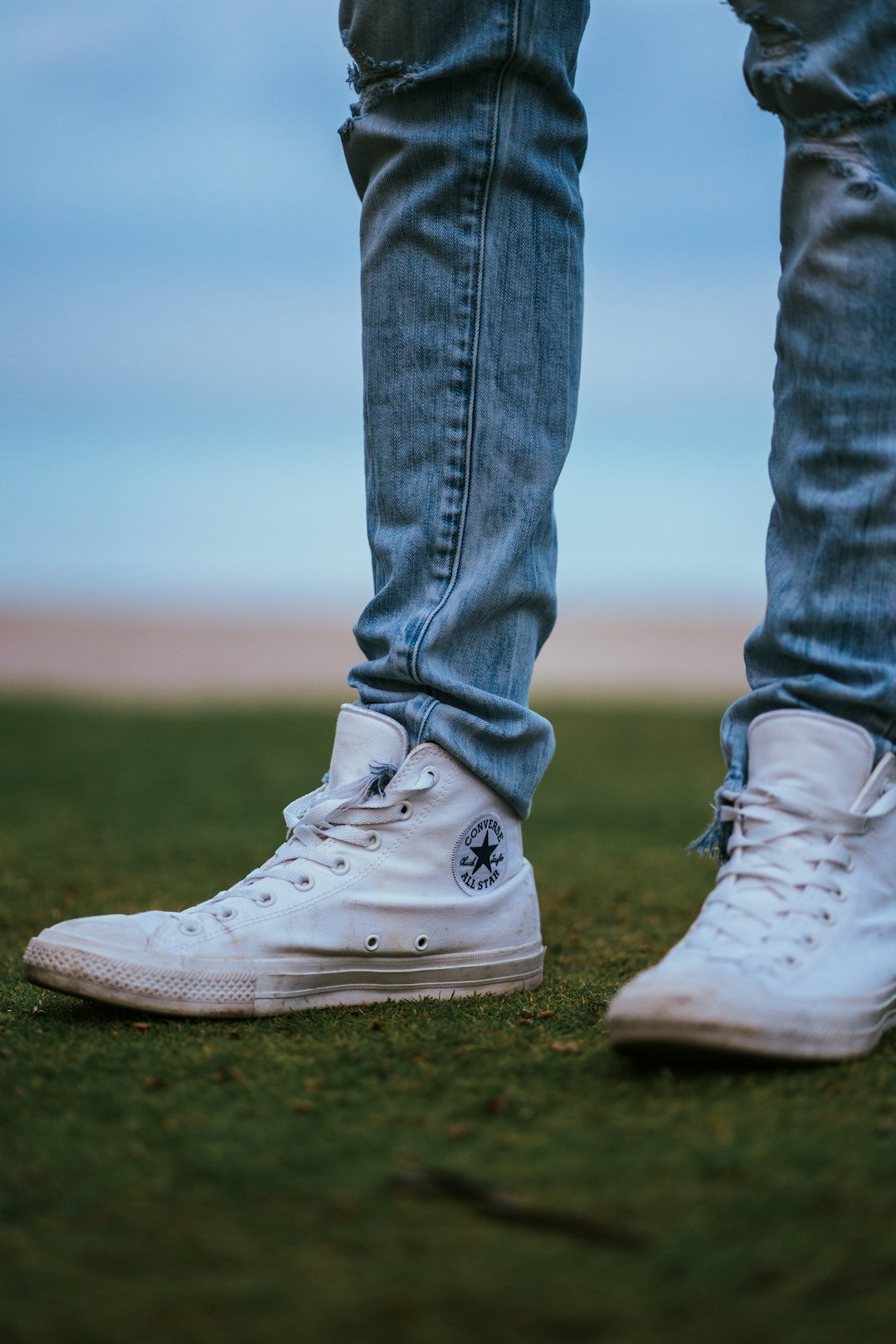 man wearing white Converse high-tops shoes