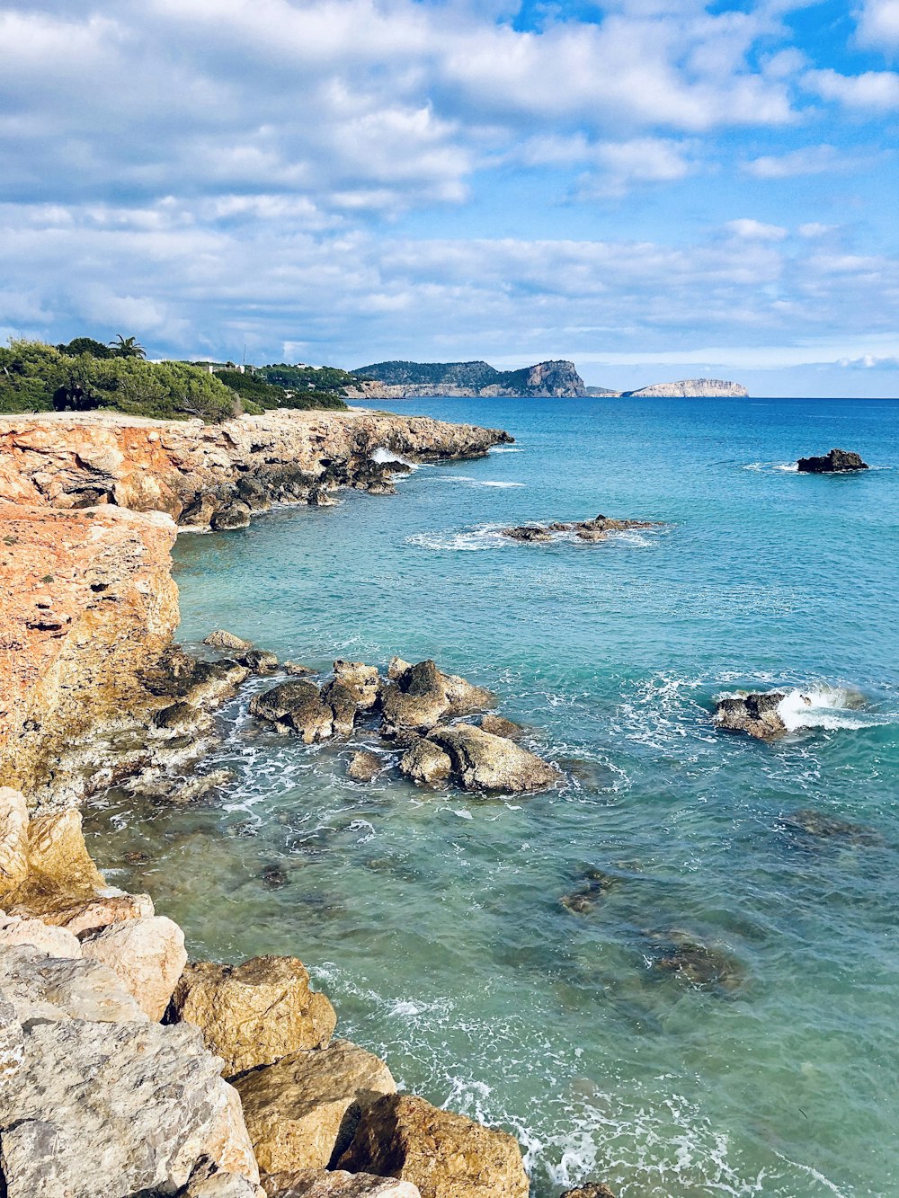 brown stone hill and sea during daytime