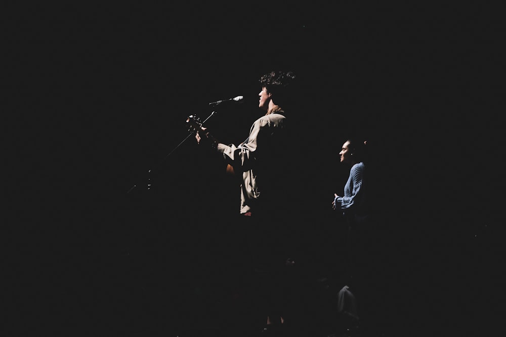 man performing on stage playing guitar