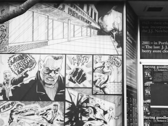 A black and white comic-style mural featuring various action scenes. The mural includes panels of intense facial expressions, fist fights, and dynamic motion lines. On the right, there is accompanying text describing the history of J.J. Newberry stores.