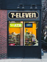 An ATM positioned near the entrance of a bustling convenience store, inviting customers to withdraw cash easily.