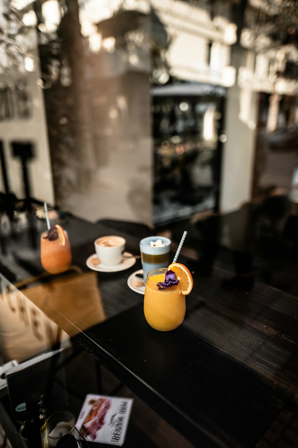 four glasses of drinks on a metal table