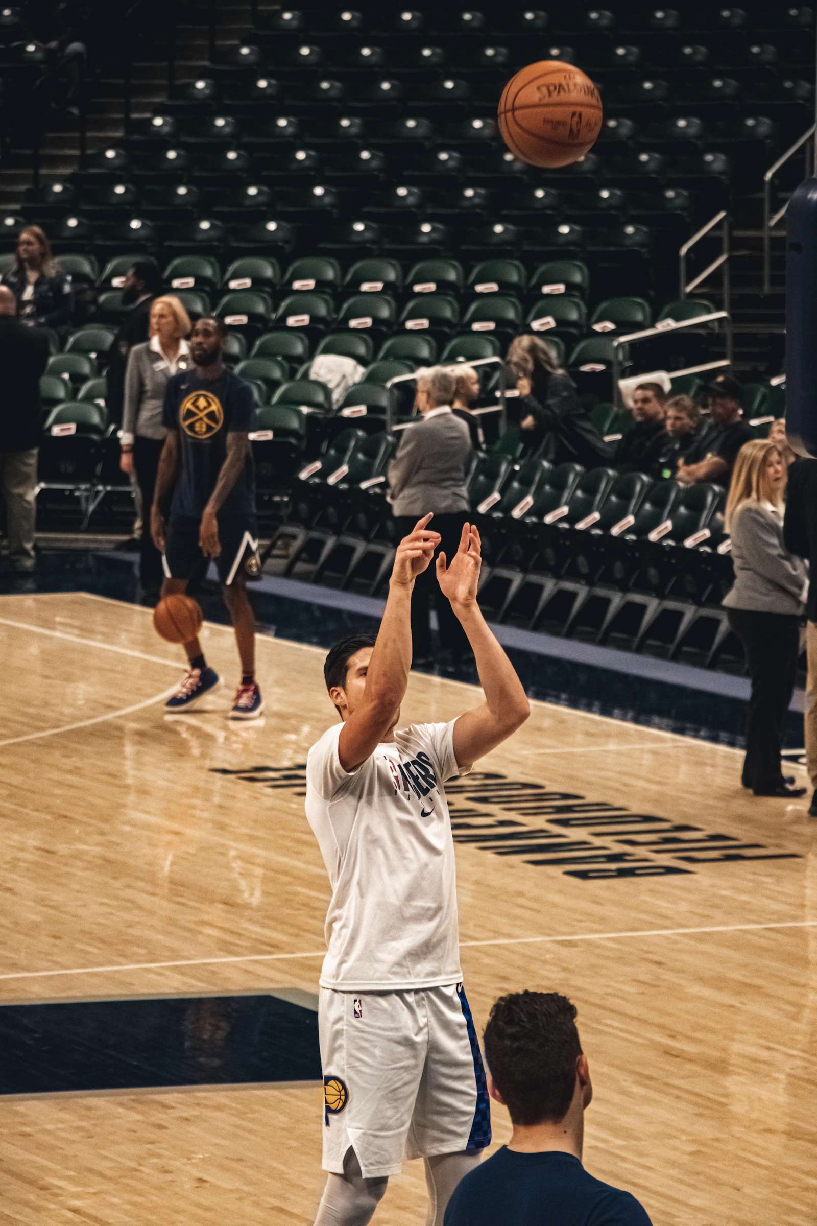 篮球馆内一名球员正在投篮热身