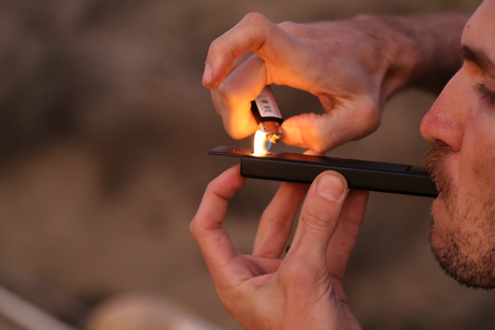 man lighting a vaporizer stick