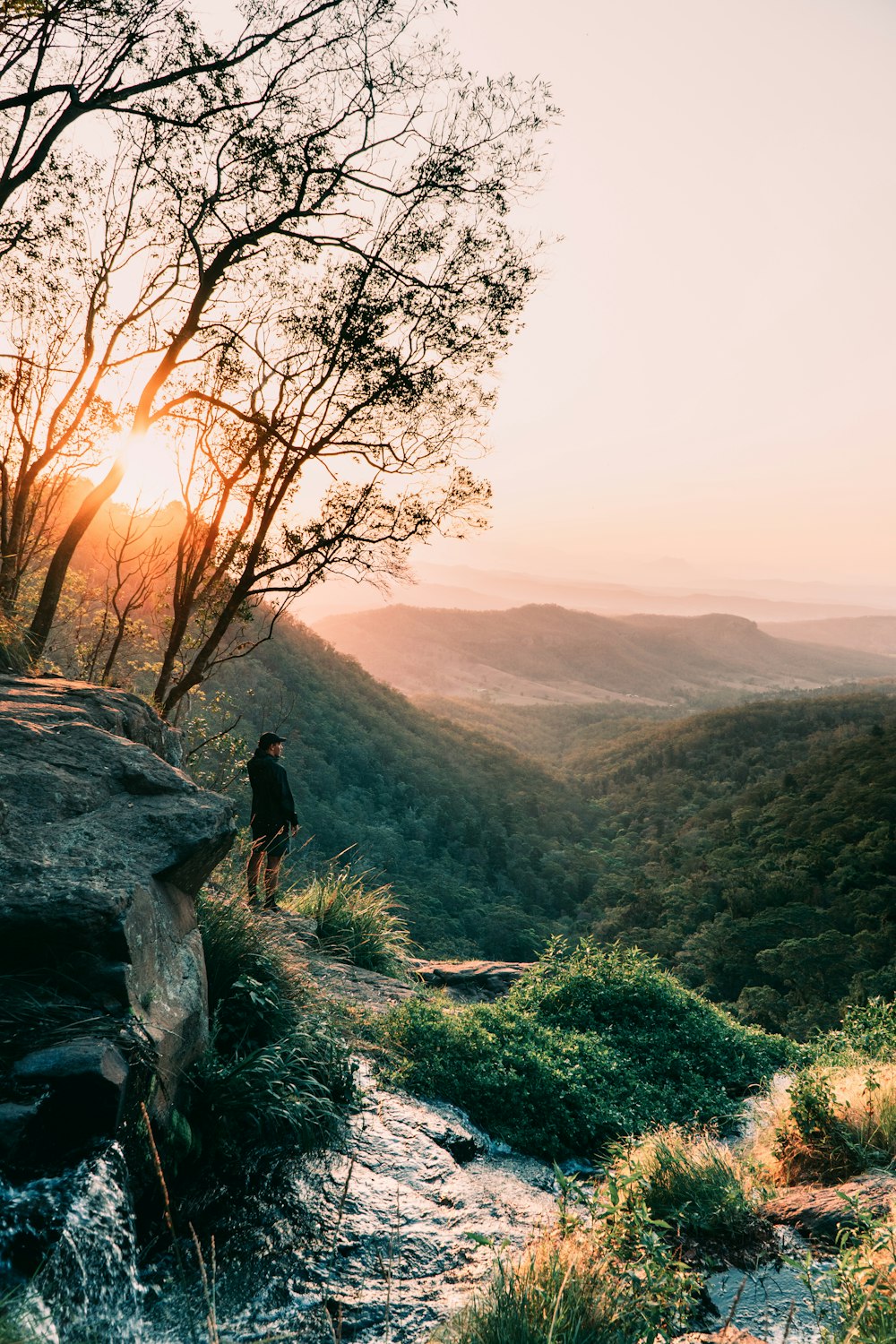 man standing on a mountain cliff during daytime