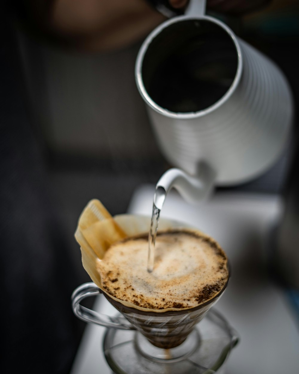 person pouring liquid in mug