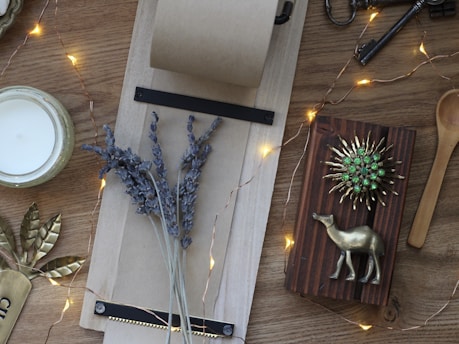 A cozy flat lay of a ritual kit with candles, herbs, and crystals on a wooden table.