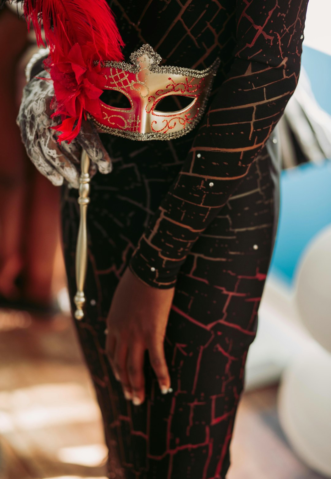 person in black dress holding gold masquerade mask