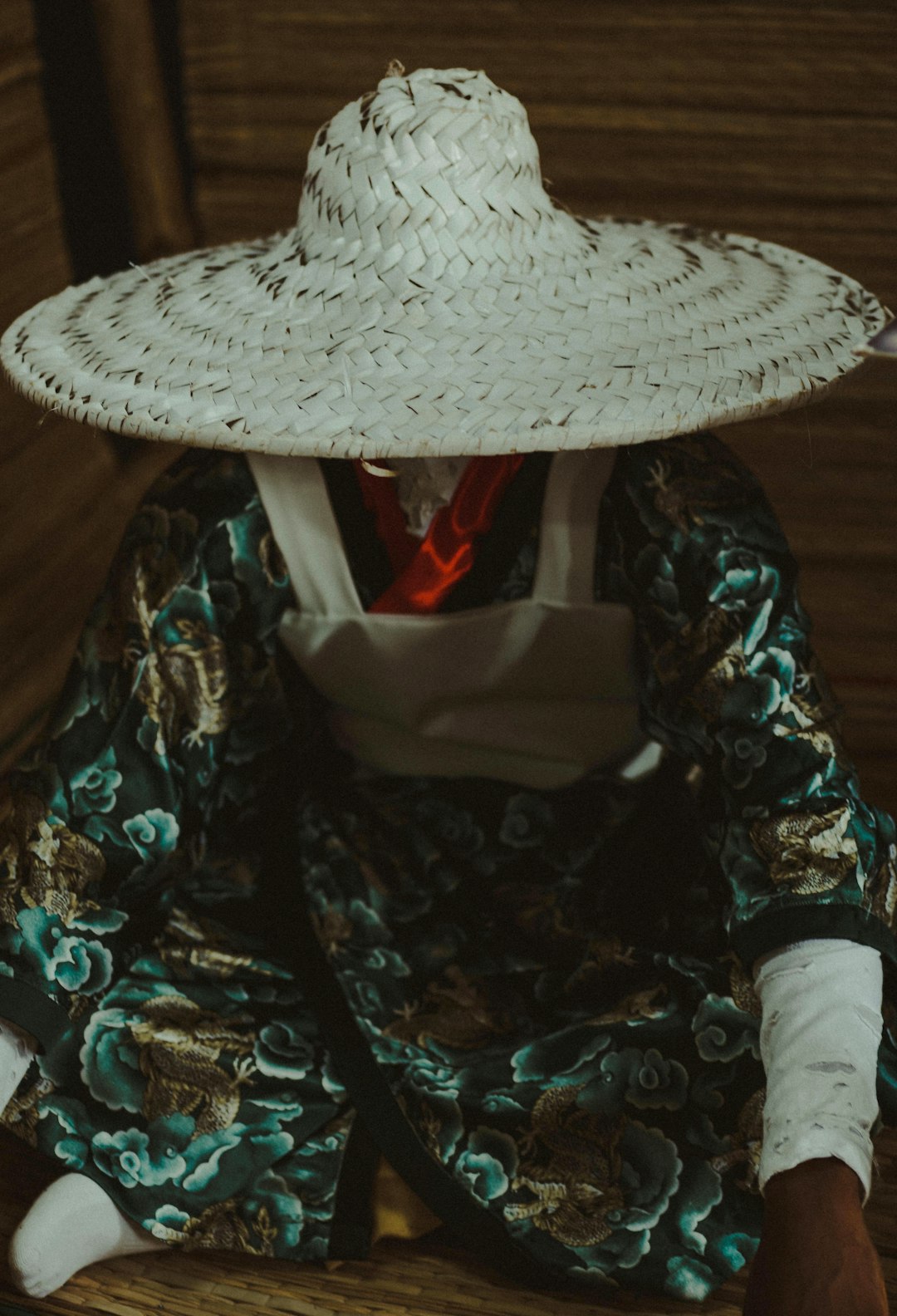 person wearing green coat sitting on floor panel