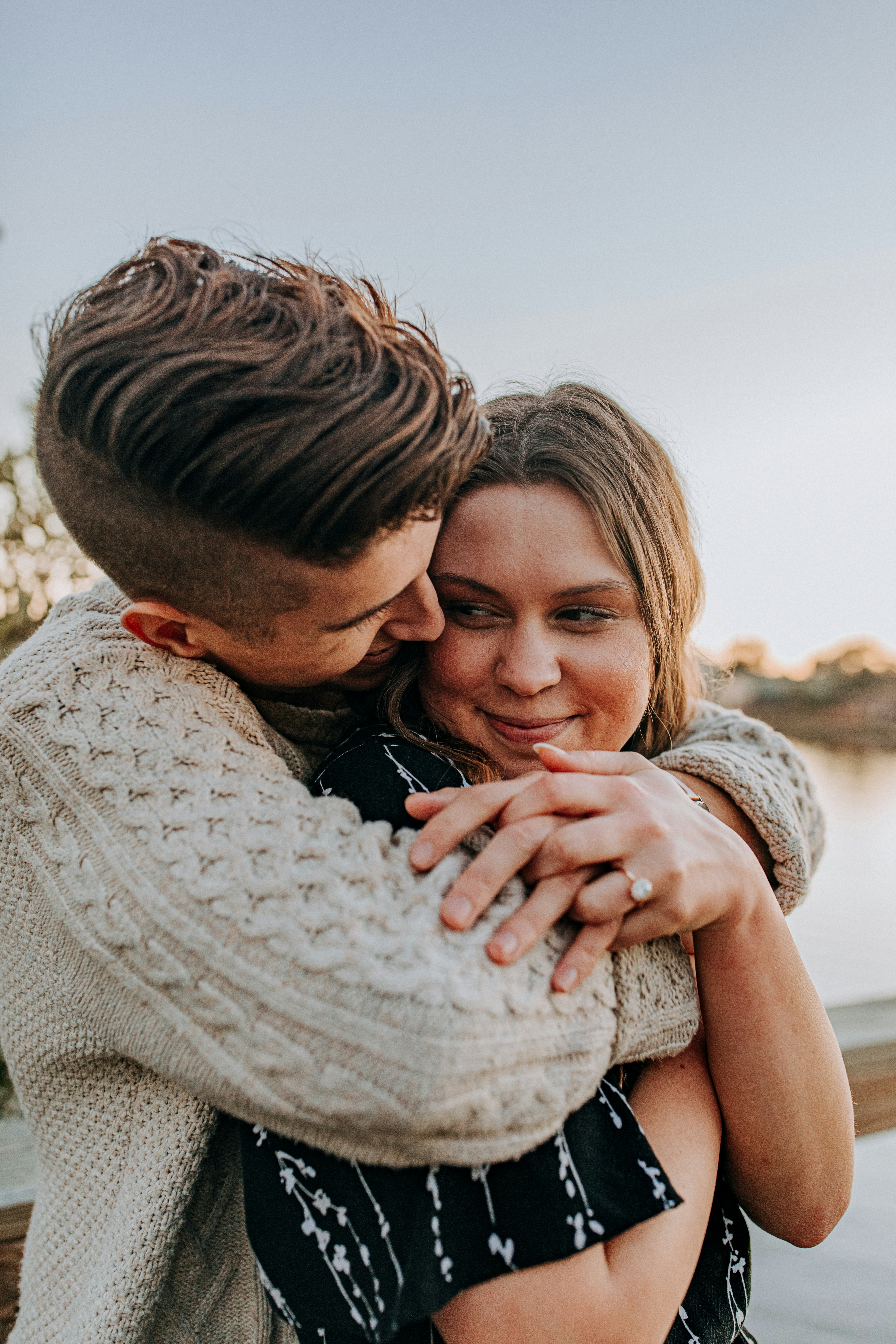 man hugging woman by her back during day