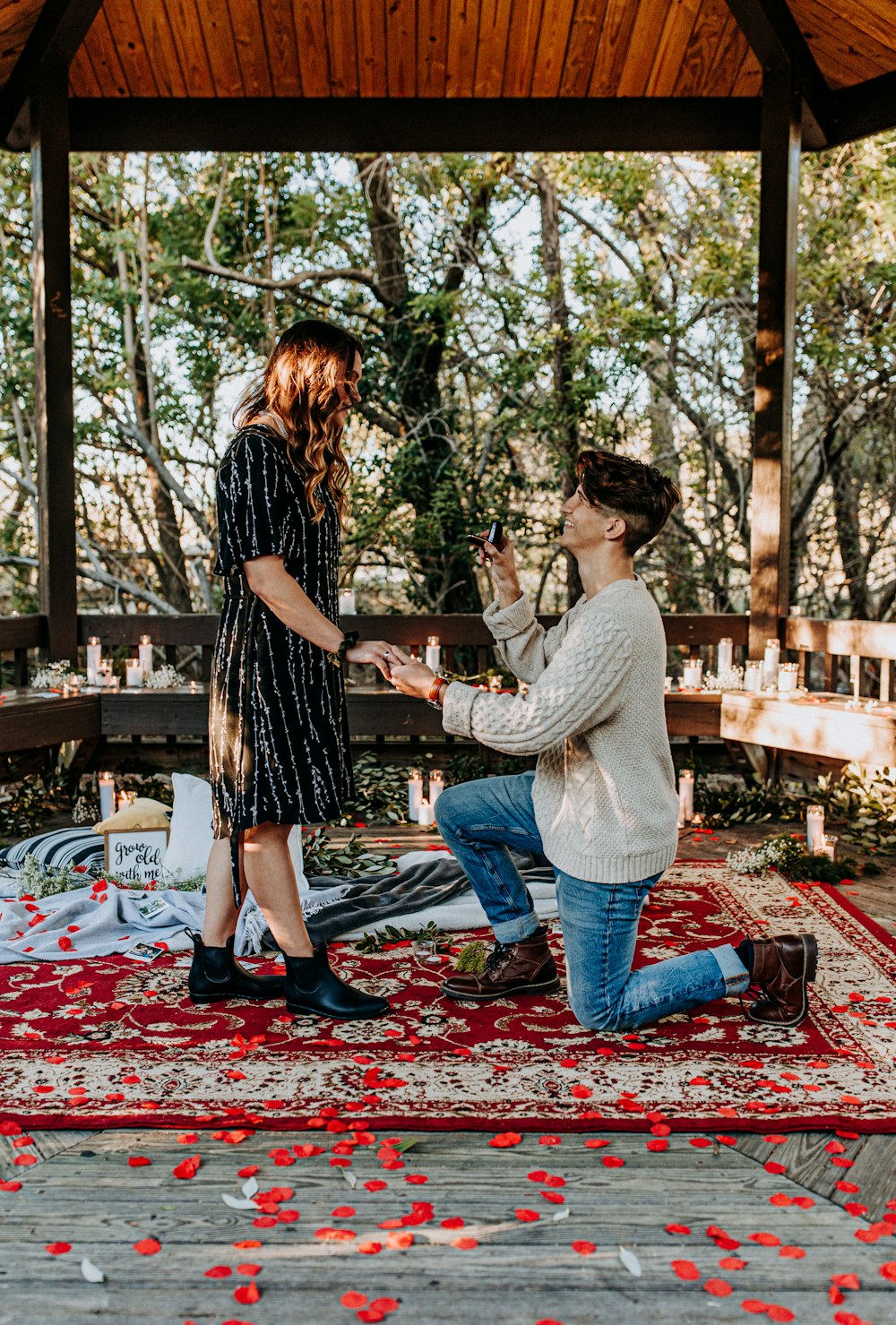 man kneeling in front of woman in gazebo during daytime