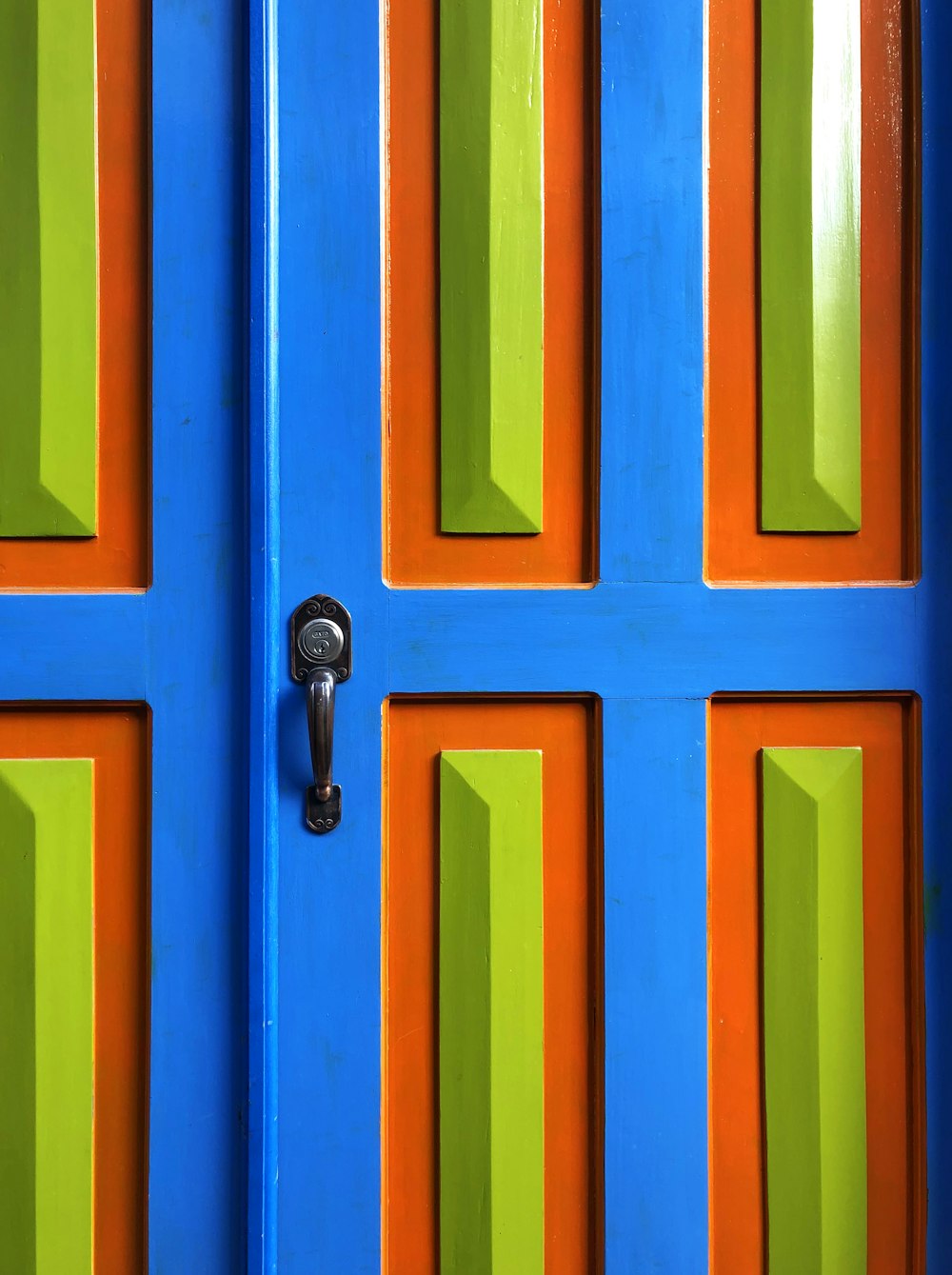 closed blue, green, and orange wooden door