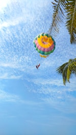 A thrilling parasailing experience with a colorful parachute soaring above the ocean.