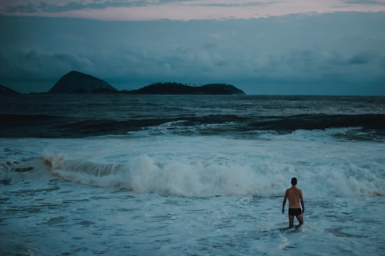 man standing beside seashore during daytime in Ipanema Brasil