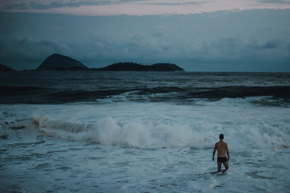 man standing beside seashore during daytime