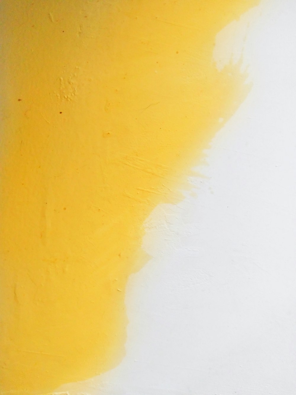 a white wall with yellow paint on it