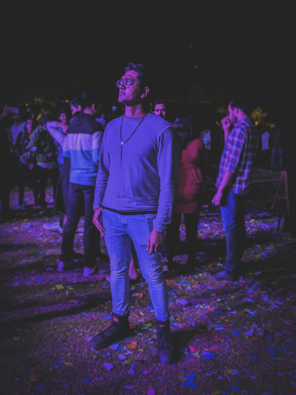 selective focus photography of standing man beside crowd at night