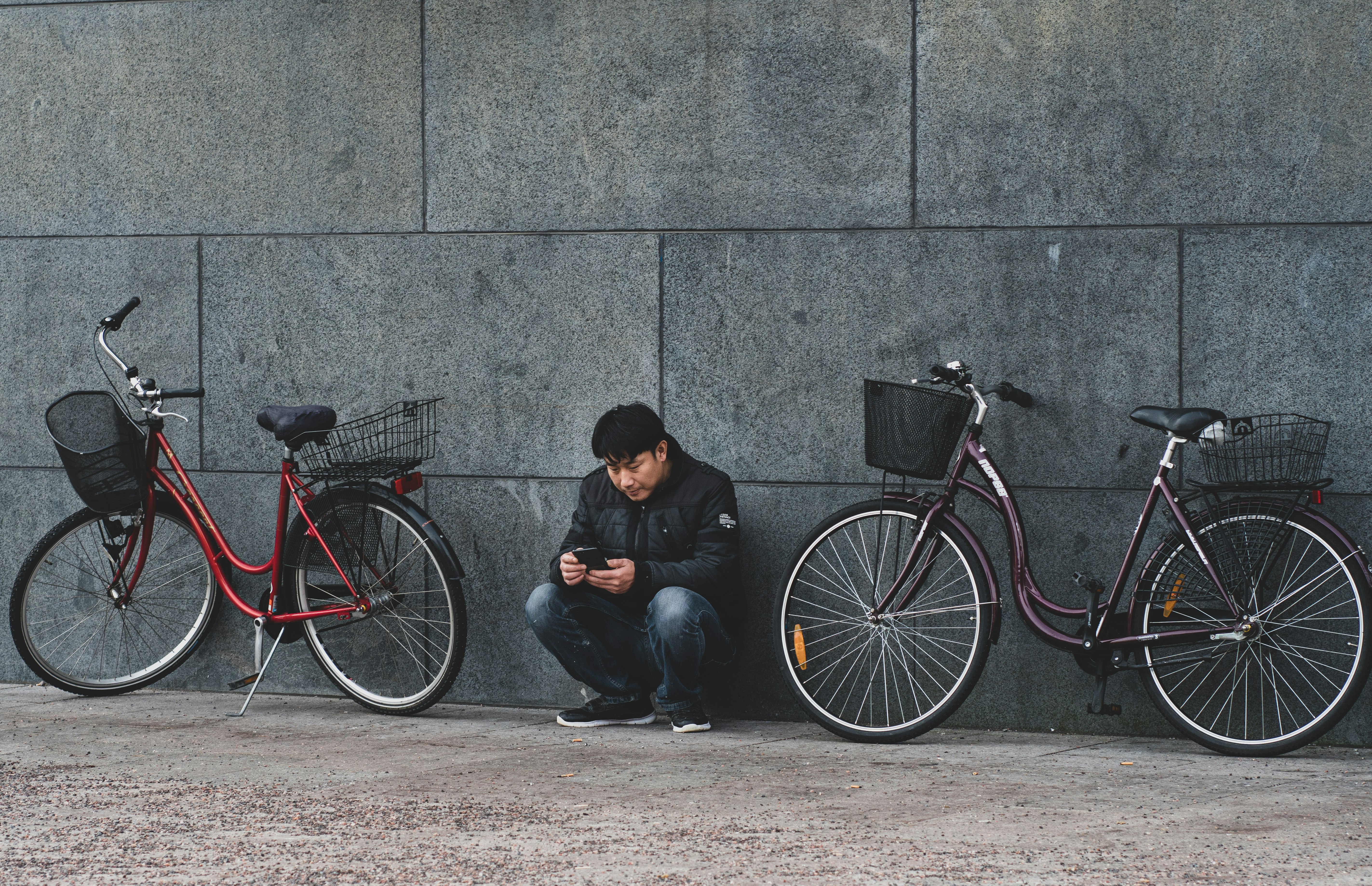 man sitting beside wall