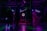 Silhouettes of people dancing in a dimly lit room with colorful, neon lighting. A neon sign displays '50's Dance' in the background, and there are balloons in various shades of pink and white on one side. The scene captures a lively and retro-themed dance event.