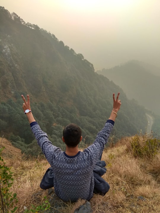 man sitting on cliff in Shimla India