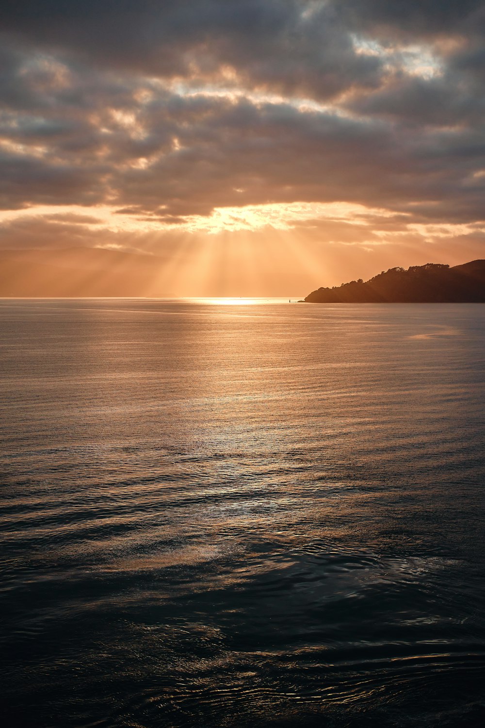 sea under cloudy sky during golden hour