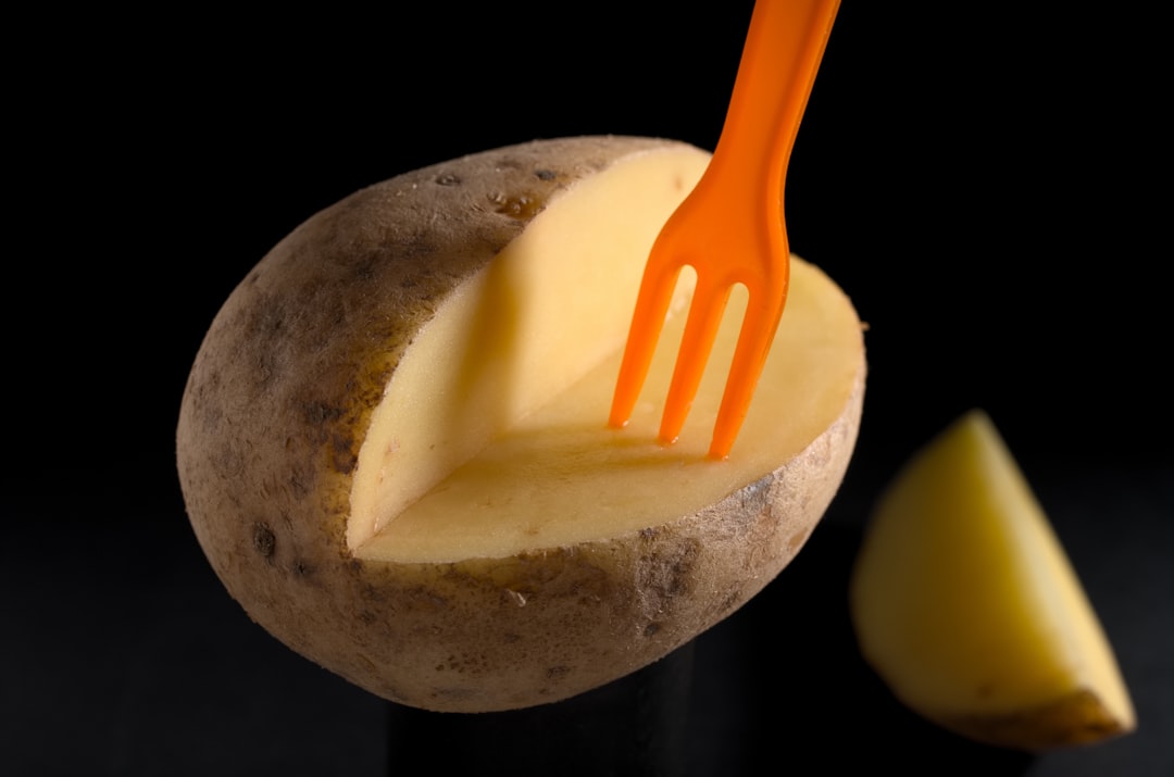 orange plastic fork on brown potato