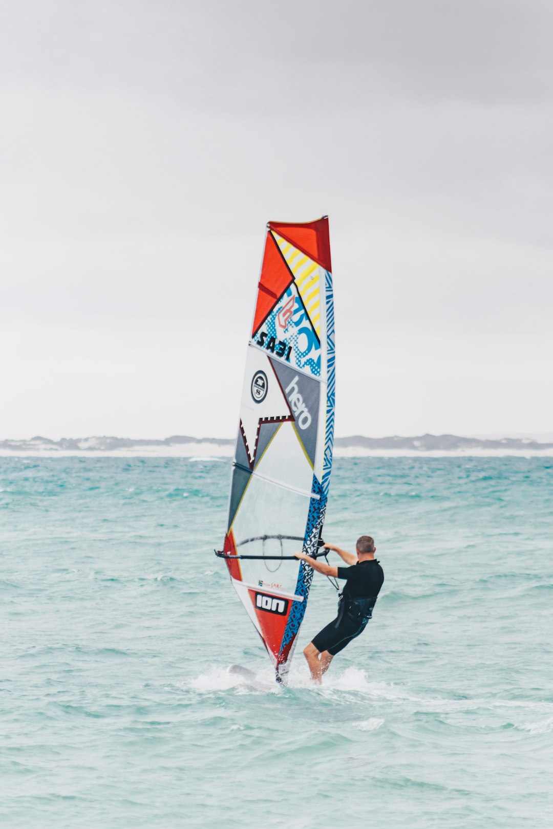 man performs windsurfing