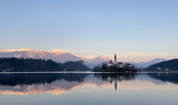 Reflection of house on body of water during golden hour — Lake Bled, Slovenia