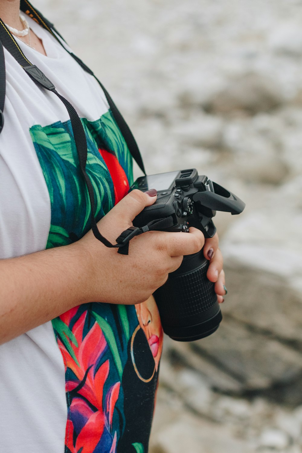 shallow focus photo of person holding black DSLR camera