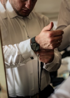 Groom adjusting his tie with a calm, focused expression before the ceremony