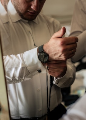 Groom adjusting his tie with a confident smile