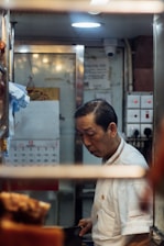 A technician carefully inspecting a commercial kitchen refrigerator.