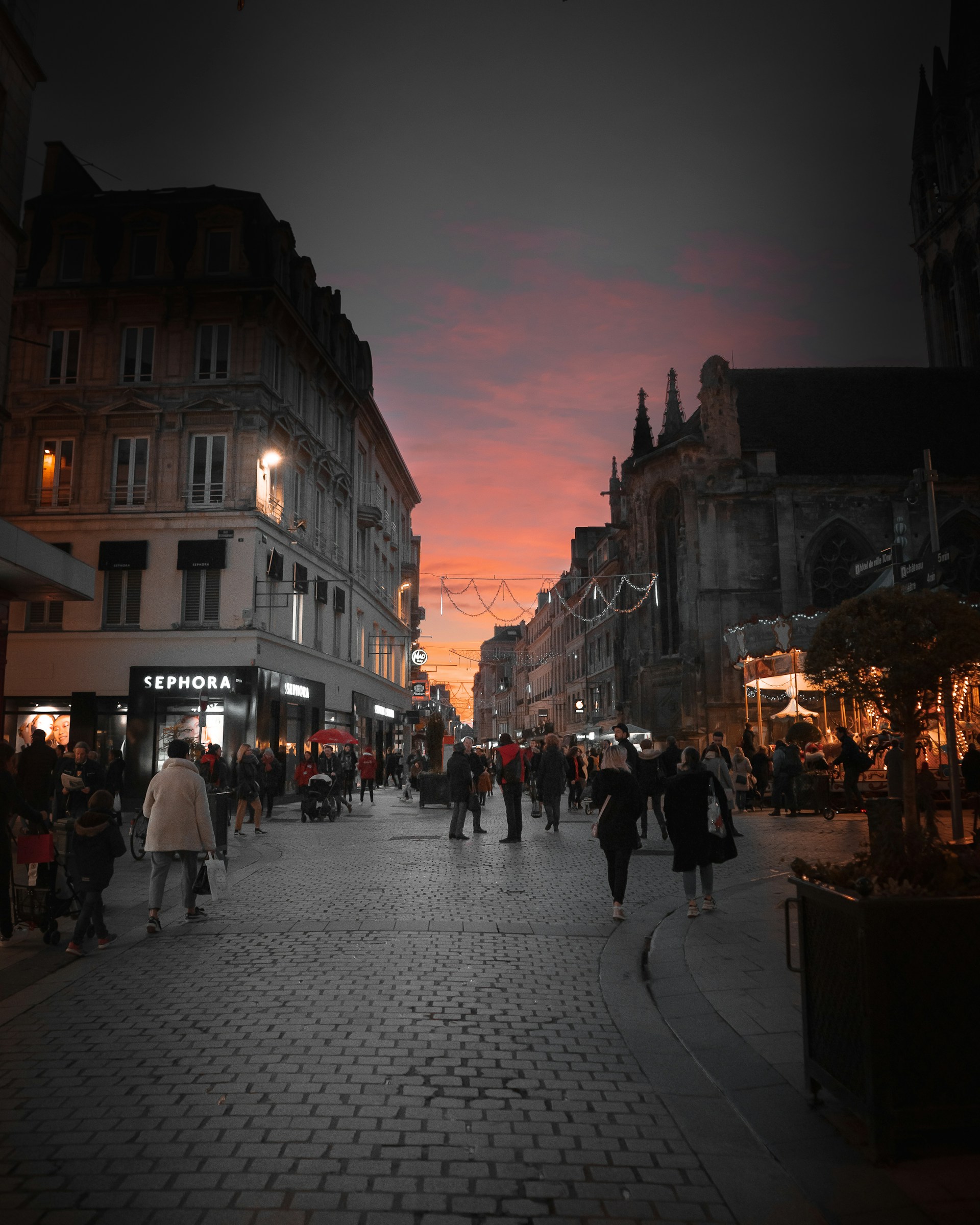 people walking on street near buildings during night time