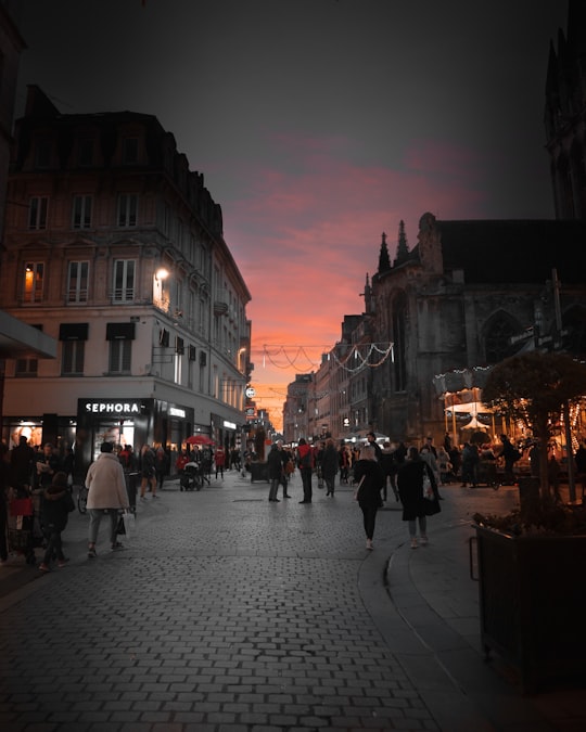 people walking on street near buildings during night time in Caen France