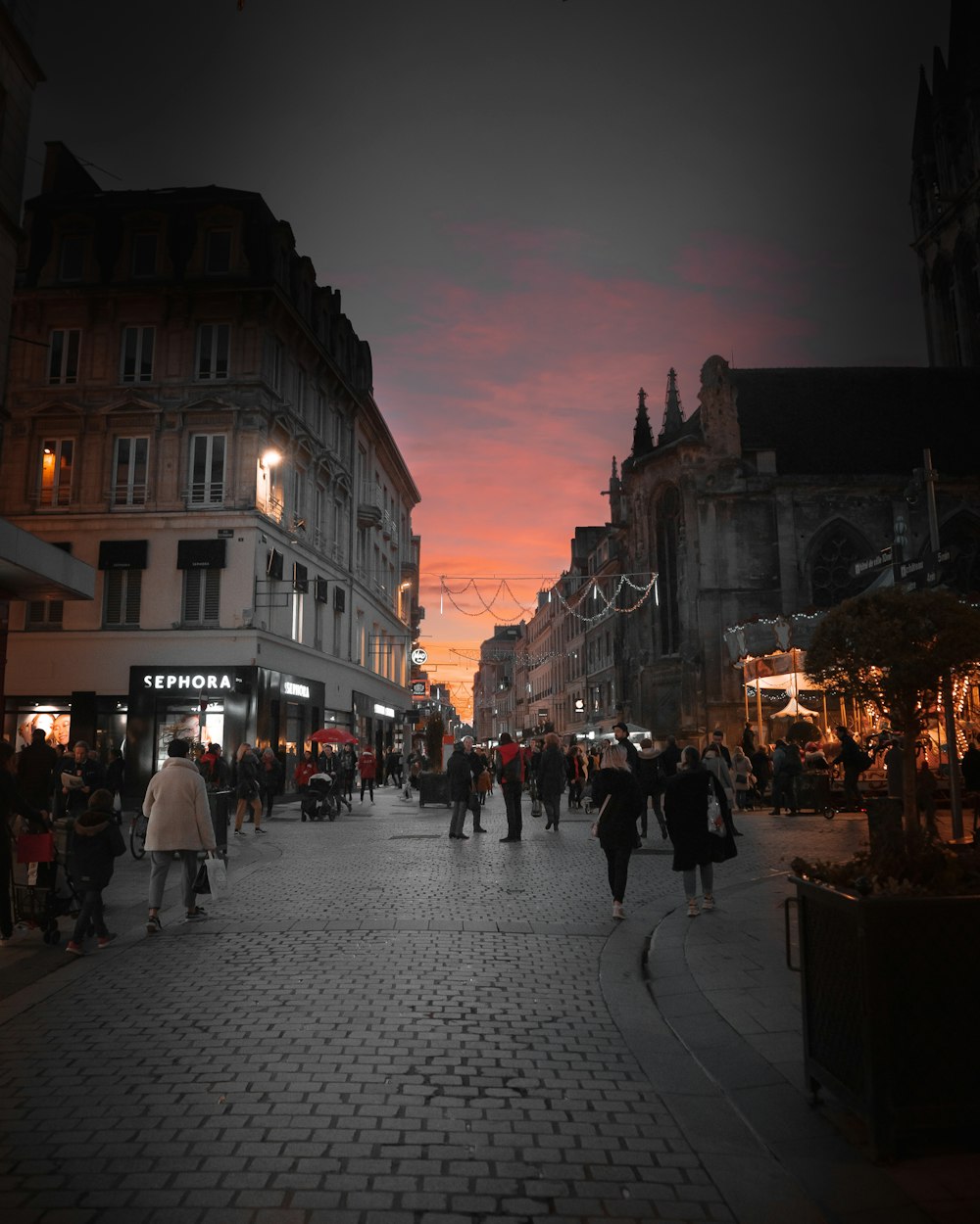 people walking on street near buildings during night time