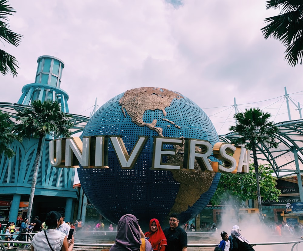 people taking photos in front of Universal globe