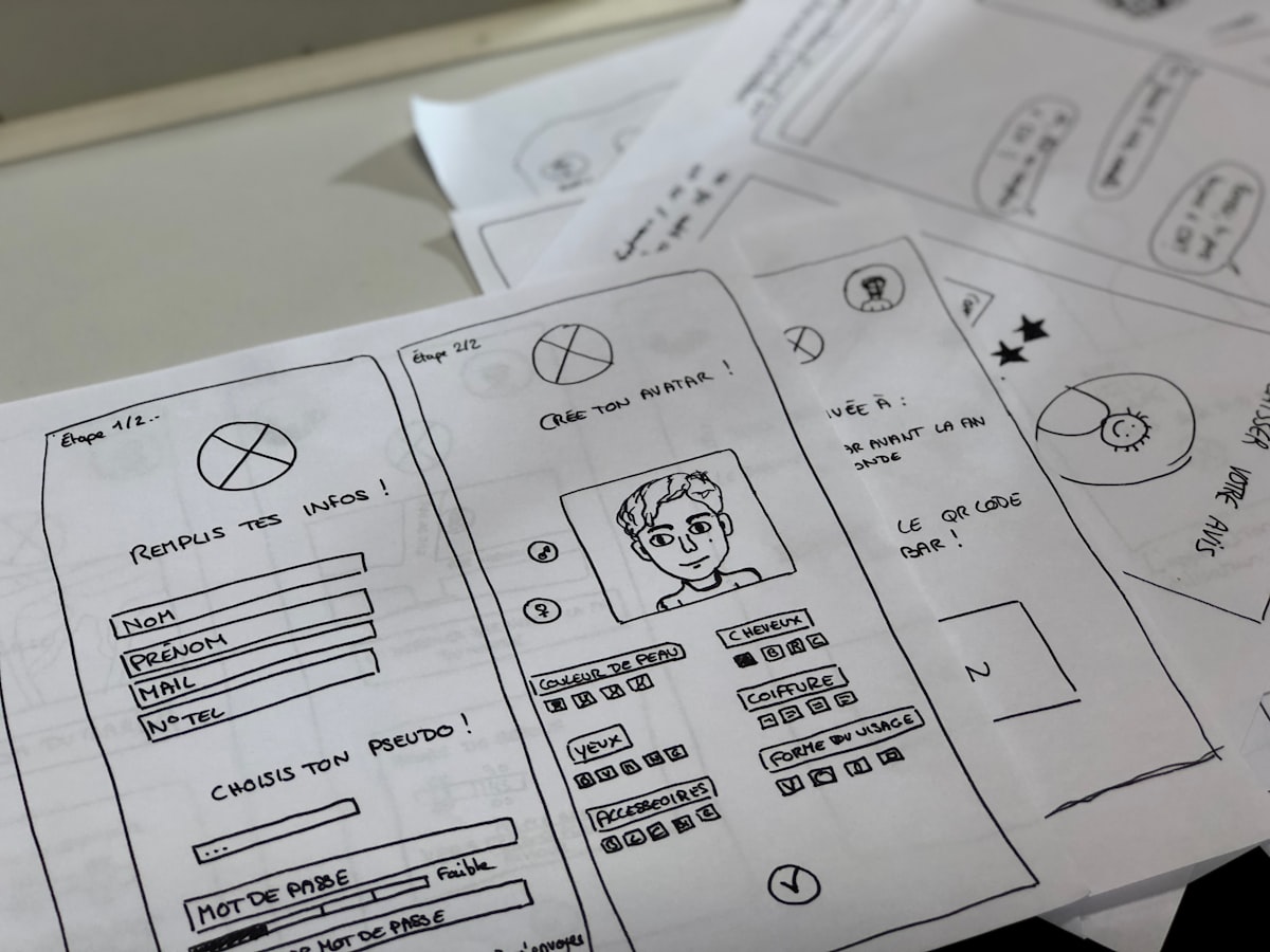 Sketsa wireframe layar pembuatan karakter MMORPG di atas kertas dengan menu pilihan customisasi avatar lengkap di meja kerja