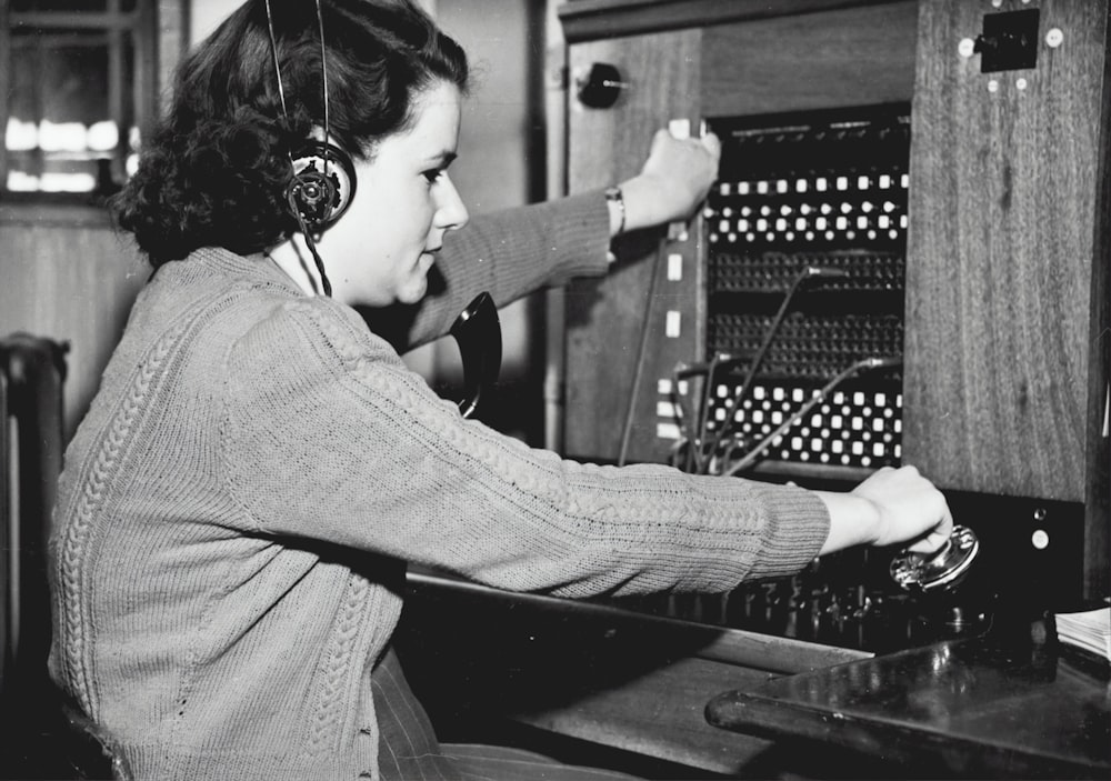 Foto en escala de grises de una mujer usando auriculares