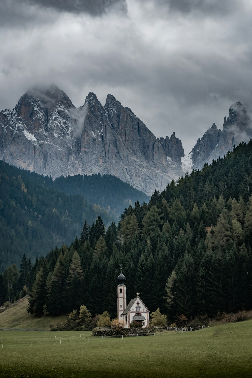 white building near green trees under cloudy sky