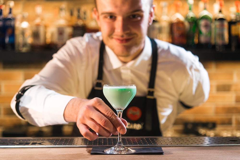 green liquid in clear footed wine glass