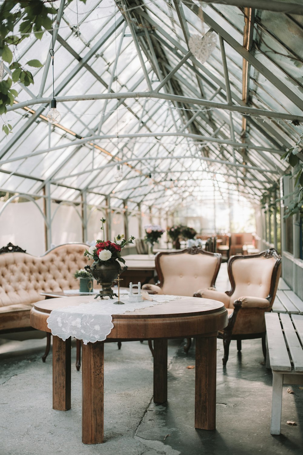 round table and peach-colored sofa set under glass ceiling