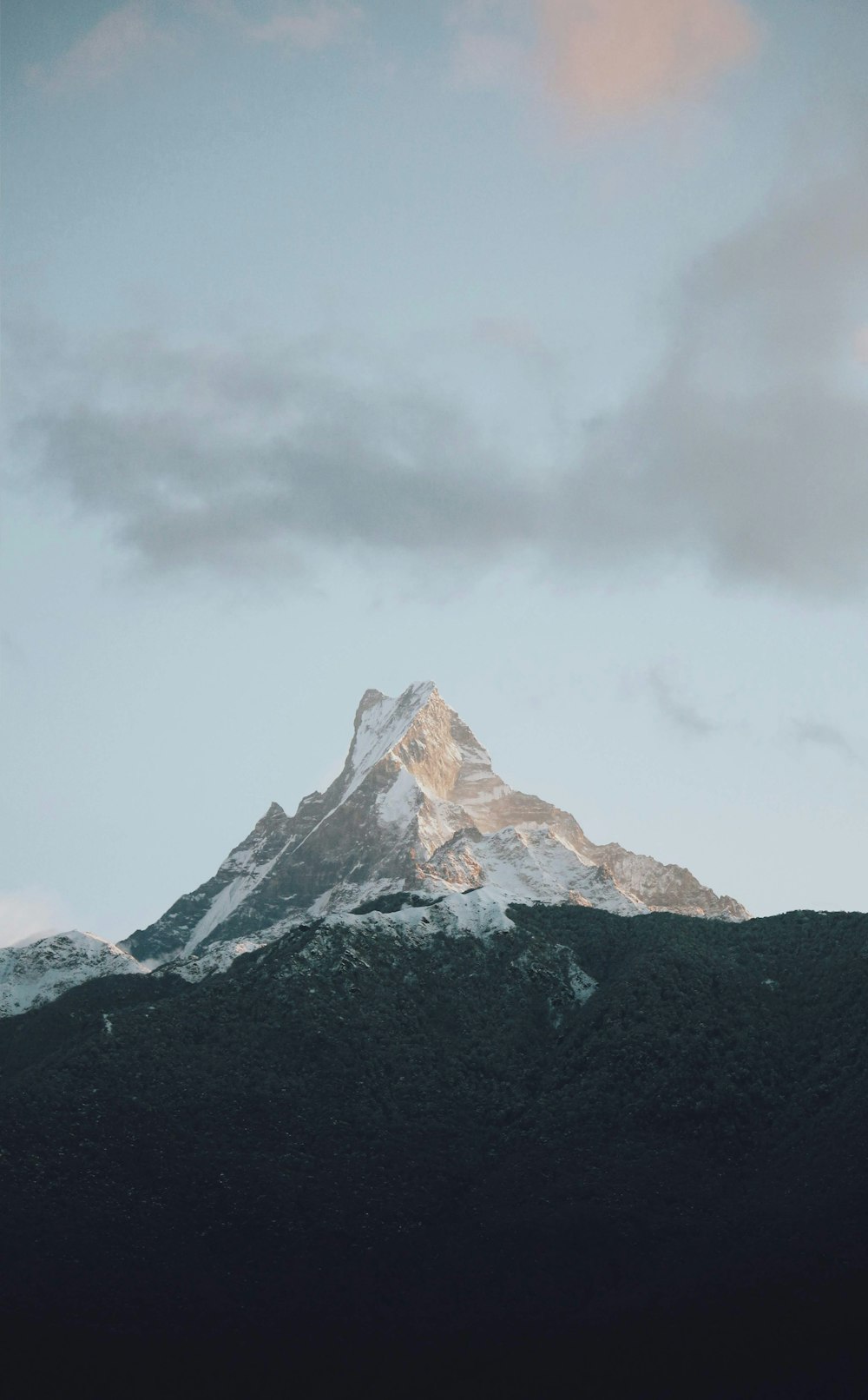 snow capped mountain under gray sky