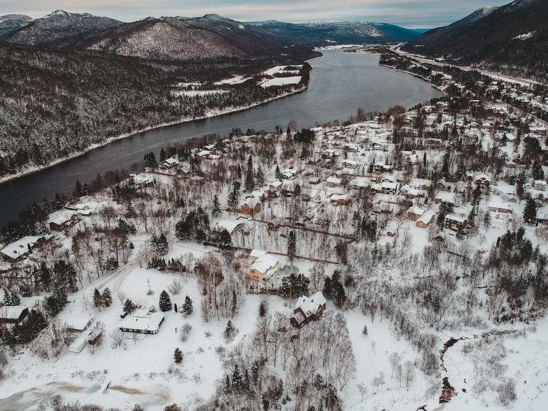 aerial photography of snow covered houses beside body of water